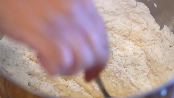 生地を作るために湿った成分に小麦粉を混ぜる フォークで攪拌スローモーション — ストック動画