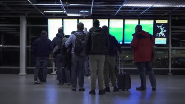 Cestující Zavazadly Při Pohledu Elektronické Obrazovce Letišti Amsterdamu Schiphol Nizozemsku — Stock video