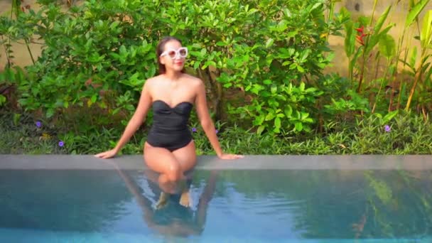 Mulher Asiática Sentada Borda Piscina Com Monokini Preto Óculos Sol — Vídeo de Stock