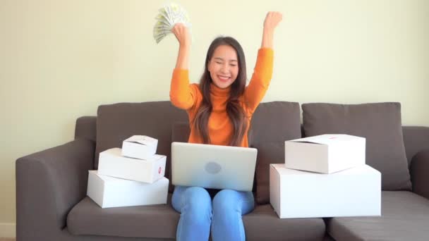 Asijské žena s notebookem a peníze v hotovosti slaví vítězství v loterii nebo Stock Rise, Full Frame