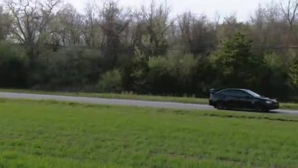 驾驶跟随射击与无人驾驶射击黑色跑车驾驶沿着风景秀丽的乡间道路 — 图库视频影像
