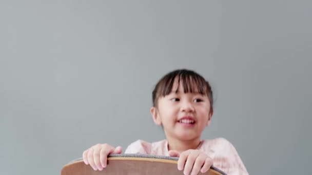 可爱的亚洲女孩坐在椅子上笑着 在房间里开心地戏弄 捉弄小孩的概念 — 图库视频影像