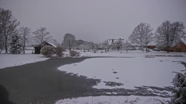自然の中で日中に氷解した湖と灰色の冬の日の時間経過ショット 5K自然池や雪と農村風景の時間経過 朝の暗い日の出 — ストック動画