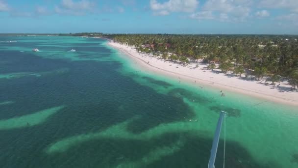 在蓬塔卡纳巴伐罗海滩透明水域航行的大金丝雀 空中飞回 — 图库视频影像