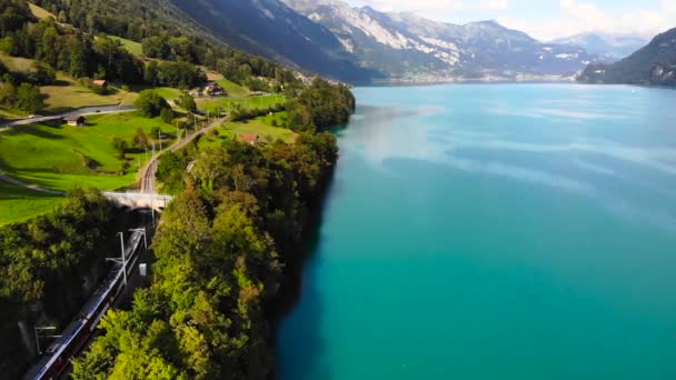 Antenne Elektrischer Zug Fährt Einem Blauen See Den Alpen Entlang — Stockvideo