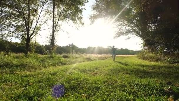 ミズーリ州のマレメック川の隣の歩道の緑のカメラに向かって歩いている男のショット — ストック動画