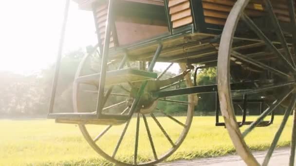 歴史的な馬車の車輪は 背景に日の出と砂の道を回転します — ストック動画