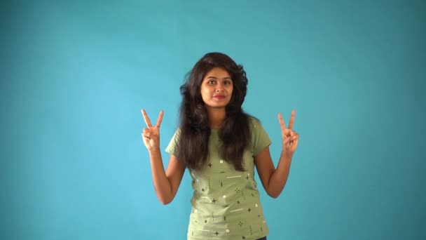 Egy Fiatal Indiai Lány Zöld Pólóban Béke Szimbólumát Mutatja Ahogy — Stock videók