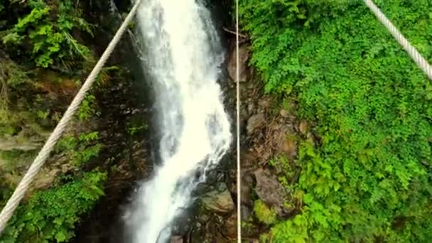 拍到一个人在钢索上向瀑布方向和瀑布上方走去 — 图库视频影像