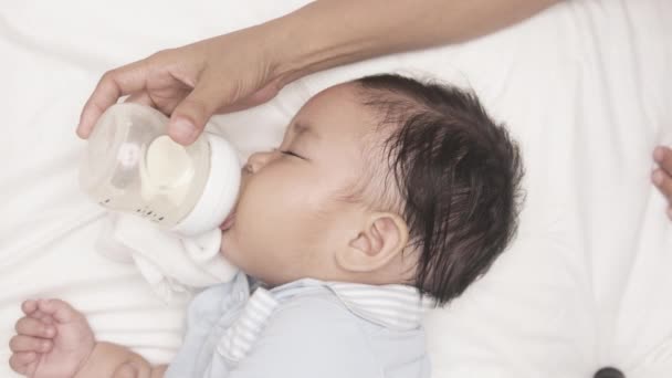 Baby Pojke Dricker Mjölk Från Utfodringsflaska Hålls Sin Mor Sängen — Stockvideo