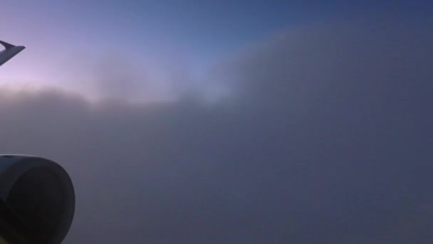 乘坐国泰航空航班与香港国际航空接近时 在橙色和紫色夕阳西下 透过黄昏的云彩 在空中看到有地平线的天空 带着引擎 — 图库视频影像