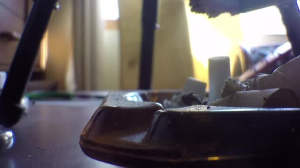 在客厅的桌子上把香烟塞进烟灰缸里 — 图库视频影像