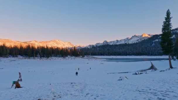 雪象马蹄湖 人们在远处行走 阳光明媚的高山和清澈的夕阳背景 — 图库视频影像