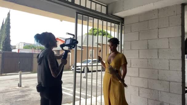 Videógrafo Filma Una Mujer Con Estilo Vestido Amarillo Brillante Junto — Vídeos de Stock