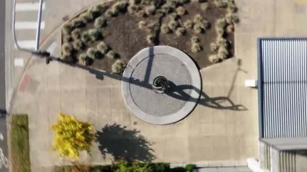 Drone Cirkelt Een Wervelende Sculptuur Met Schaduw Buiten Een Gebouw — Stockvideo