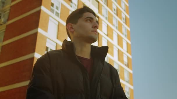 Portret Młodego Mężczyzny Stojącego Przed Kompleksem Mieszkaniowym Niski Kąt — Wideo stockowe