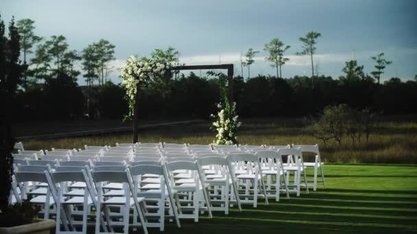 Outdoor wedding ceremony setup with white chairs