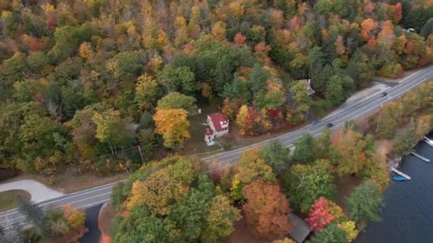 Sunapee湖 カラフルな紅葉と湖畔の家 ドローンショットによる海岸道路上の交通の空中ビュー — ストック動画