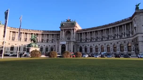 ウィーン オーストリア 観光客や車が通り過ぎる晴れた日には ホフブルク城の右から左へのモーションビュー 人気の観光地と街の重要なランドマーク — ストック動画