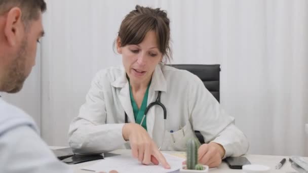 Ženský doktor vysvětlující pacientce v její klinice. střední snímek