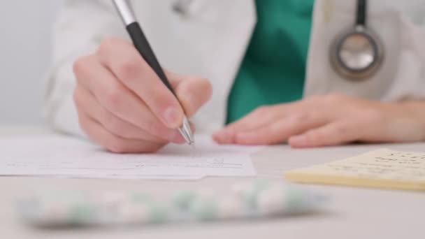 Doctors Hand Writing Prescription On The Table In The Clinic. close up