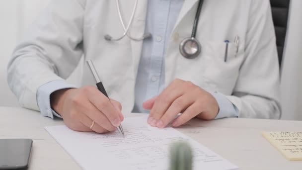 医者は白い紙に彼の医学診断を書く ミディアムショット — ストック動画