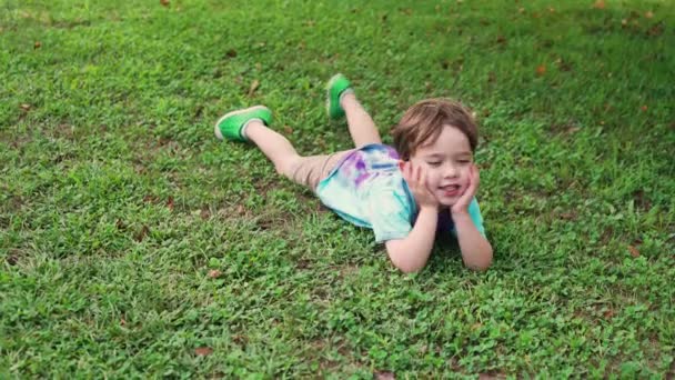 Yalıtılmış Sıkılmış Bir Amerikan Çocuğunun Çimlerin Üzerinde Yatışı — Stok video