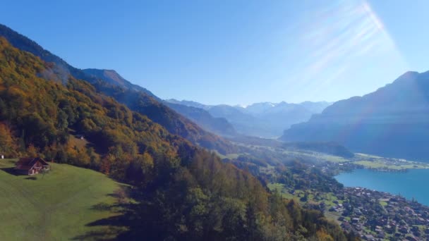 美しい湖の上の丘の上にシングルホームの空中ドローンビューとブリエンツスイス ヨーロッパの山々をアルプス — ストック動画
