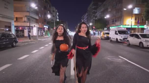 Meninas Trajes Bruxa Andando Estrada Segurando Abóbora Vassouras Tiro Largo — Vídeo de Stock