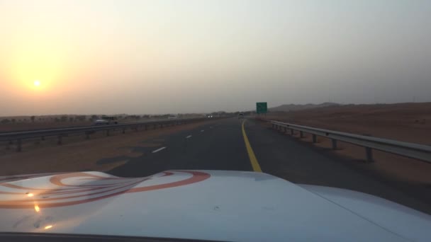 日落时带着沙漠沙尘沿着迪拜公路行驶 — 图库视频影像