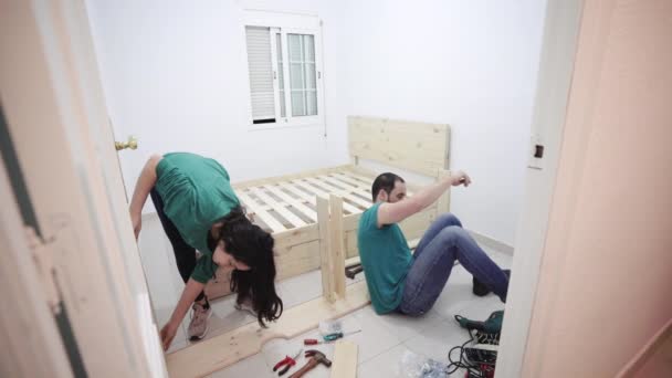 自宅で一緒にベッドを構築する生産的なパニックカップル — ストック動画