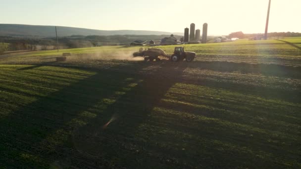 トラクターは 米国ペンシルベニア州農村部で午後遅くにトウモロコシの茎のベールをドロップ — ストック動画