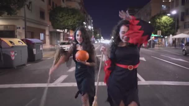 Duas Meninas Bonitas Andando Uma Estrada Vazia Vestindo Trajes Halloween — Vídeo de Stock