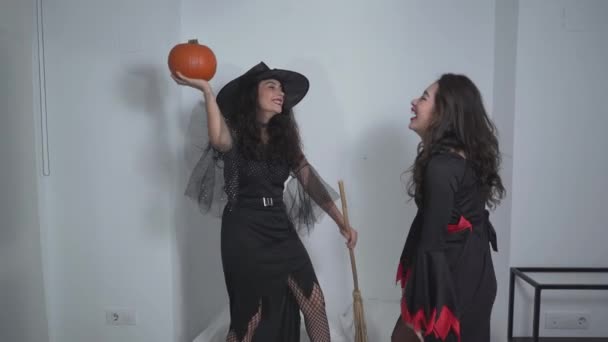 Dos Adorables Colombianas Vistiendo Trajes Bruja Divirtiéndose Sosteniendo Una Calabaza — Vídeos de Stock