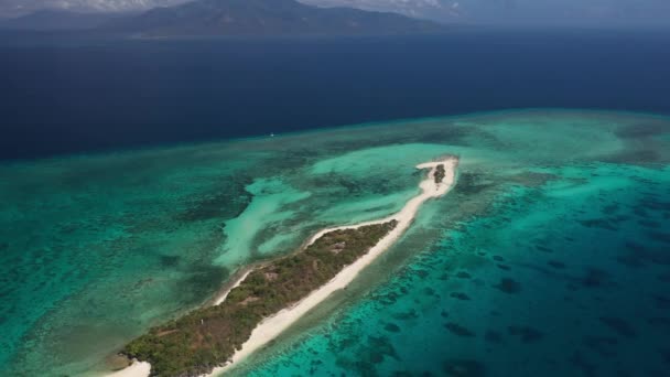 フィリピンのクレスタ ガロ島の空中撮影 白い砂浜と緑の木々が青い海とターコイズブルーの鮮やかな海と遠くの大きなサンゴ礁と山をミックスします — ストック動画