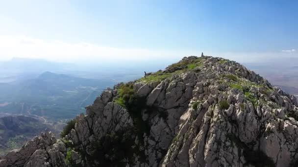 一个年轻的当地黑人男子从山坡上走下来 跳下一块巨石的边缘 站在山顶的悬崖上 向外眺望宏伟壮丽的风景 — 图库视频影像