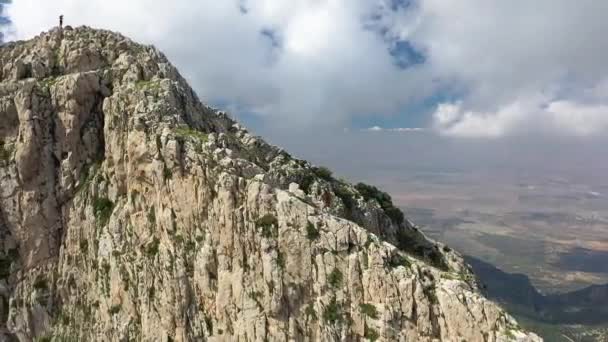 地元の黒人男性は 彼のすぐ隣に急な崖で山の端を慎重にハイキングしている アドレナリンとスリルは チュニジアのザグワーンのピークからのハイキングを求めて — ストック動画