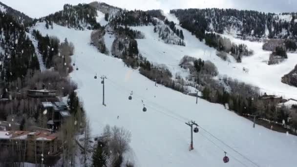 雪の中 ケーブルカーで雄大なスキー場の斜面 空中上昇ビュー — ストック動画