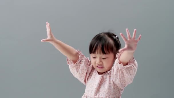 Malá Asijská Dívka Šatech Úsměvem Mává Rukama Dívá Kamery Studiu — Stock video