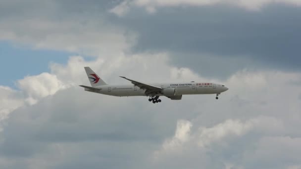 在多伦多Yyz皮尔逊国际机场发现 东方航空公司波音777飞机在乌云密布的天空中飞行 阳光照射在飞机上 — 图库视频影像