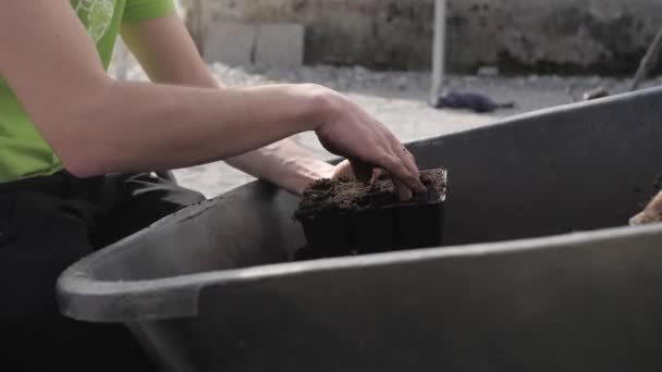 Mann Legt Mit Bloßen Händen Erde Von Schubkarre Plastikbehälter Nahaufnahme — Stockvideo