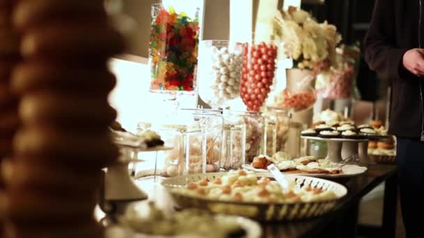 お菓子やチョコレートと結婚式のレセプションパーティーフードビュッフェテーブル — ストック動画