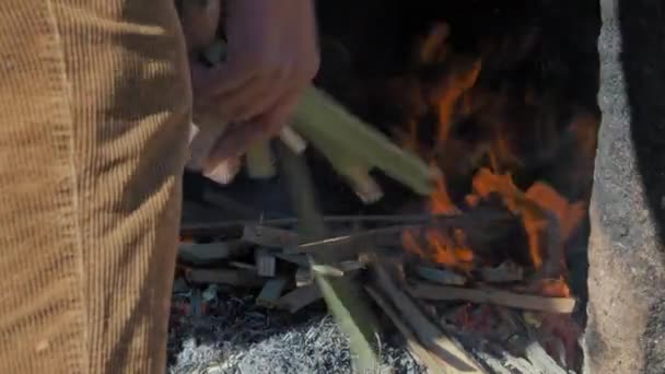 Mann Wirft Holzstücke Ein Feuer Einem Steinofen Für Die Töpferei — Stockvideo