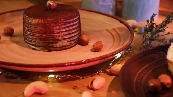 Lahodný čokoládový dort a kokosový Eclair na talířích s oříšky roztroušenými na stole. Dezert Flatlay Concept. close up, slider shot