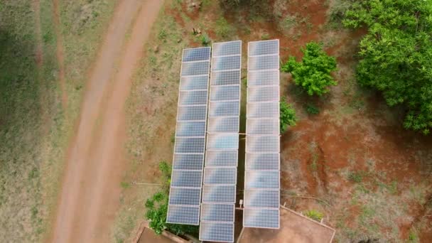 太陽光によるアフリカの農村部の水システム 4K太陽光パネルファーム 太陽電池 の空中ビュー 太陽光パネルフィールド上のドローン飛行再生可能な緑の代替エネルギー — ストック動画