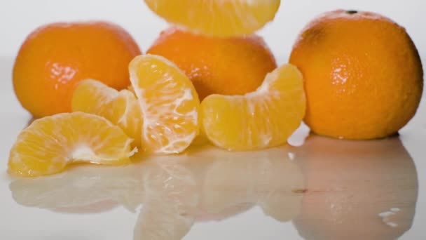 Noch Angeschossene Mandarinenfrüchte Auf Nasser Oberfläche Scheibe Fällt Auf Weißem — Stockvideo