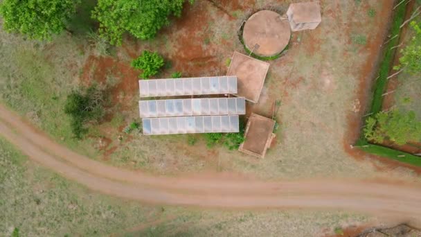 太陽光によるアフリカの農村部の水システム 4K太陽光パネルファーム 太陽電池 の空中ビュー 太陽光パネルフィールド上のドローン飛行再生可能な緑の代替エネルギー — ストック動画