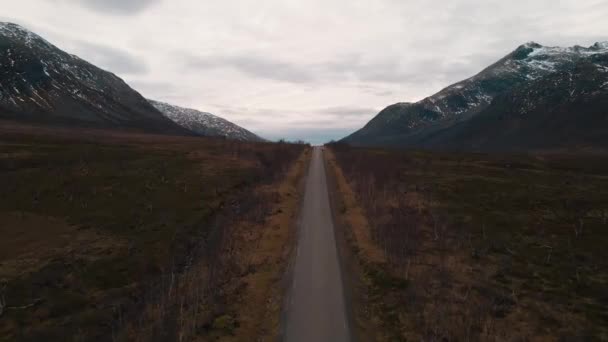 雪の山はノルウェーのKvaloya近くの谷に沿って道路を取り囲みます — ストック動画