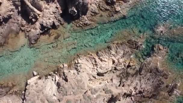サルデーニャ島の南にある中国の砂浜の真ん中にある岩の上にドローンが浮かんでいます — ストック動画