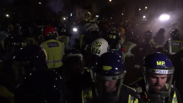 都市防暴警察形成警戒线 并在夜间举行的百万面具大游行中 面对着向他们投掷的烟雾弹 — 图库视频影像